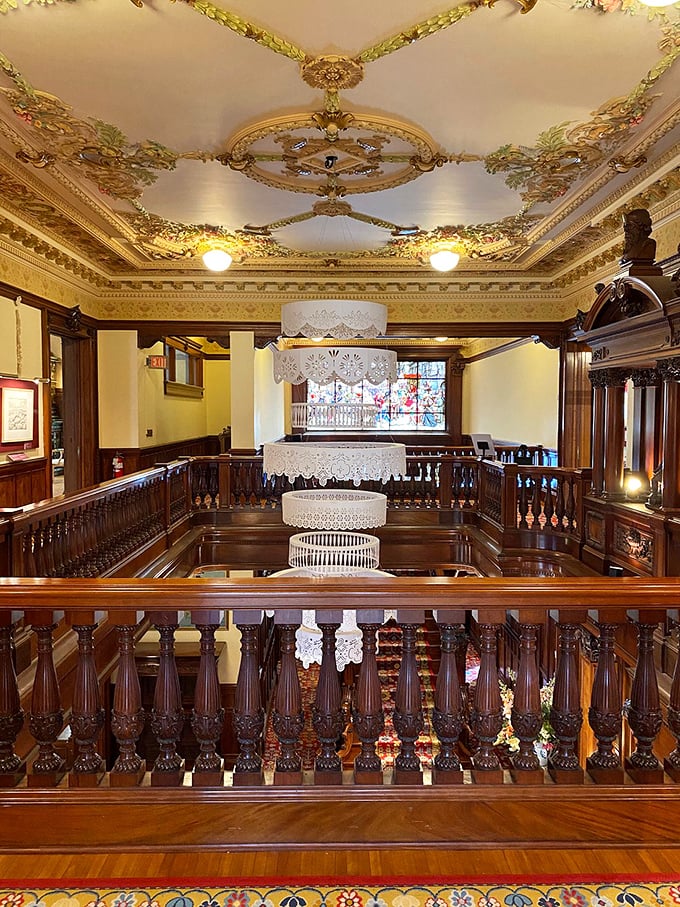 Chandeliers and wood carvings, oh my! This ceiling is busier than a Swedish smörgåsbord on Christmas Eve.