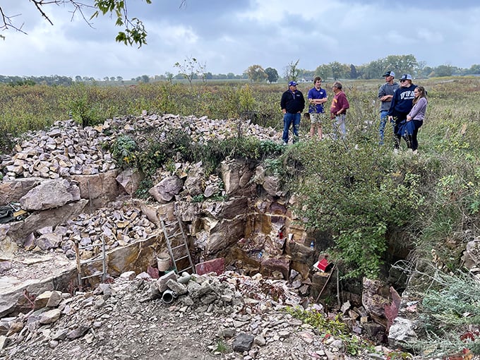 Gather 'round, folks! These visitors are getting the scoop on Pipestone's rocky past. It's like a book club, but with better views.