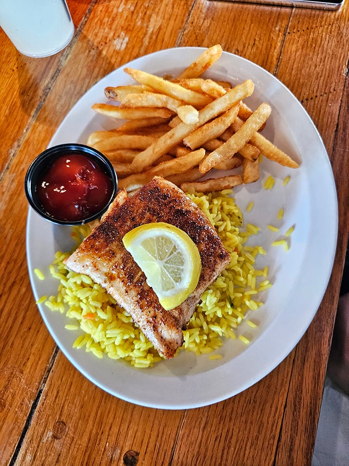 Surf meets turf in perfect harmony. This plate's got more layers than a seafaring onion - crispy fries, zesty rice, and a fish fillet fit for Poseidon himself.