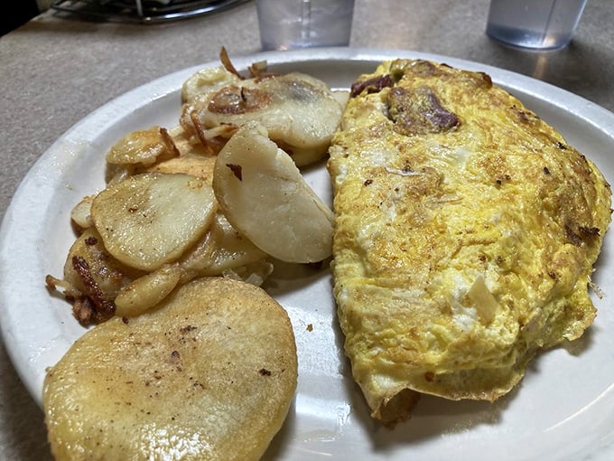 Eggs-cellent choice! This omelet, packed with goodies and flanked by crispy potatoes, is the breakfast of champions – and regular folks who just love good grub.