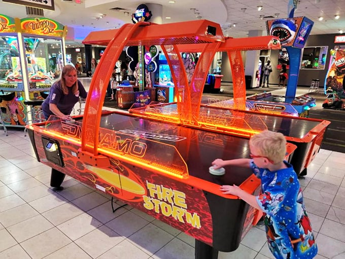 Air hockey showdown in progress! Watch as families battle it out, proving that competitive spirit is indeed hereditary.