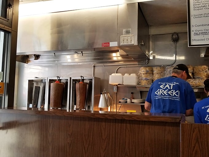 Behind the scenes, where the magic happens. These blue-shirted culinary wizards are the unsung heroes of your Greek feast.