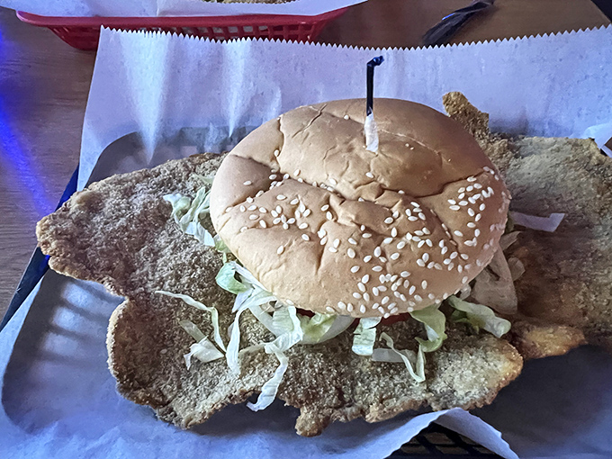 This isn't just a sandwich; it's a feat of culinary engineering. The bun's playing hide-and-seek with a tenderloin that's auditioning for a role in "Honey, I Shrunk the Pig!"