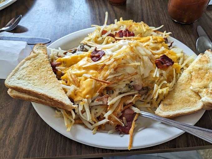 Behold, the Leaning Tower of Hashbrowns! This stuffed spud skyscraper is a carb lover's dream, flanked by toast soldiers ready for dipping duty.