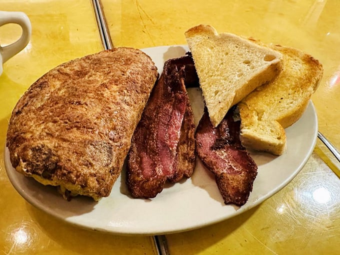 Eggs-cellent choice! This smoky omelet, flanked by crispy bacon and golden toast, is the breakfast equivalent of a warm bear hug.