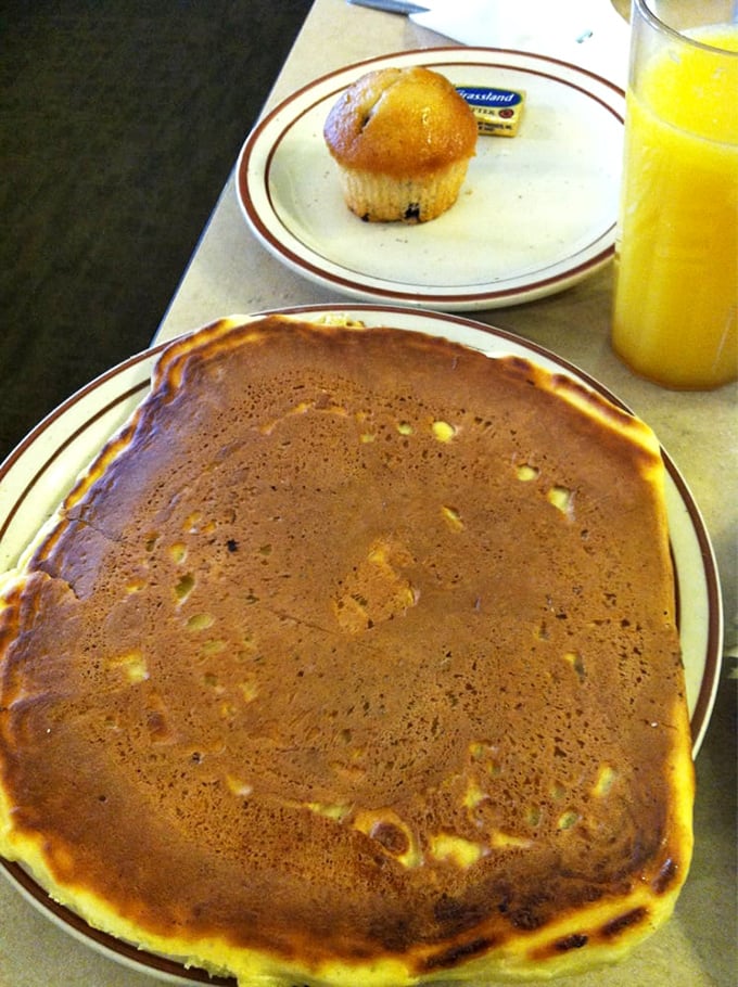 Pancake or edible frisbee? This golden-brown beauty is so massive it barely fits on the plate. It's not just breakfast; it's an engineering marvel with syrup.