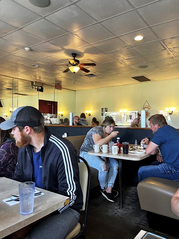 Breakfast bliss in action! These diners aren't just eating; they're participating in a time-honored ritual of coffee, conversation, and carb-loading. It's democracy in delicious motion.