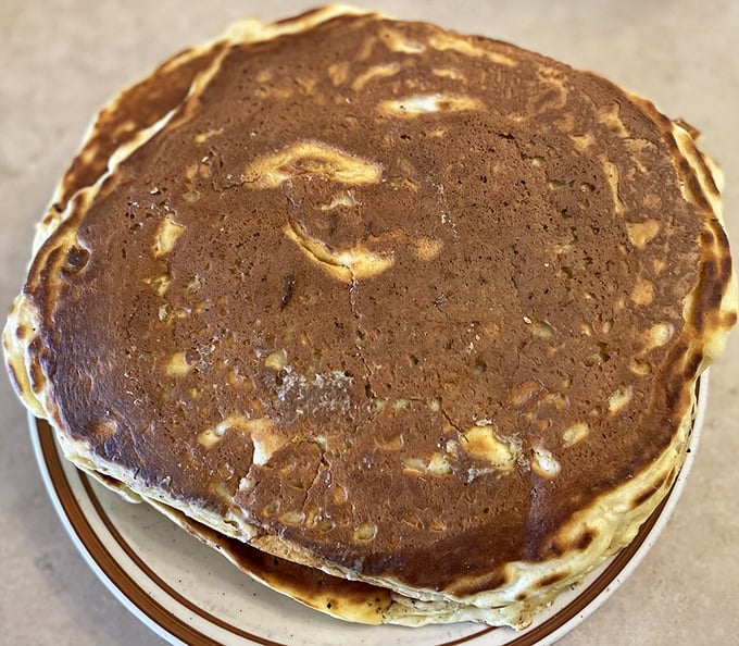 Behold, the pancake in its natural habitat! Golden, fluffy, and large enough to use as a lap blanket. It's not just breakfast; it's an edible hug for your taste buds.