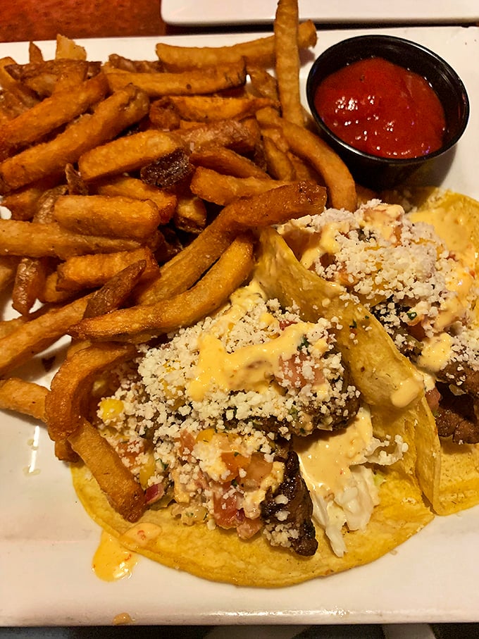 When tacos meet French fries, it's like a delicious cultural summit where everyone wins. The sauce drizzle adds that perfect finishing touch. Photo credit: Mallory Herb