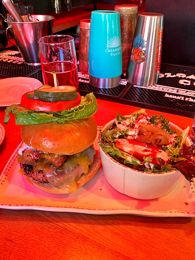 The burger arrives like a rockstar with its entourage – a fresh side salad that proves even the supporting acts here deserve standing ovations. Photo credit: Jackie G