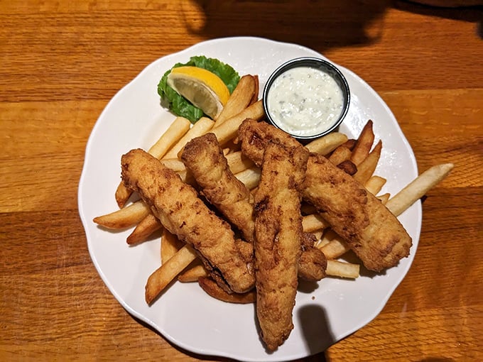 Fish and chips done right: crispy, flaky haddock strips perched atop a mountain of perfectly golden fries.