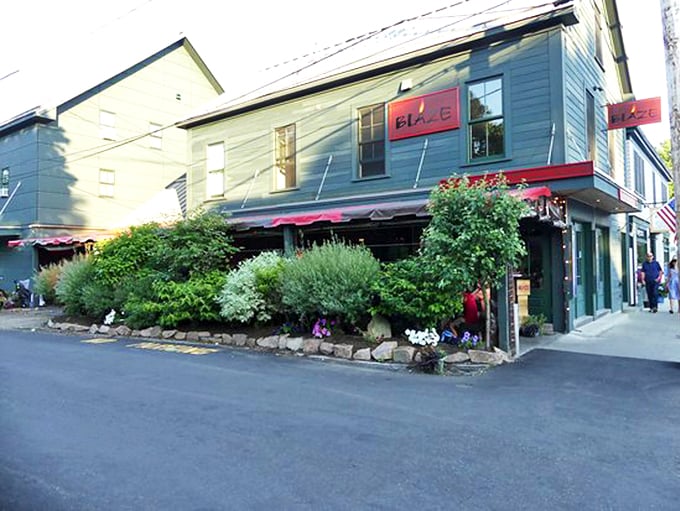 Welcome to flavor town! Blaze's charming exterior, with its lush greenery and inviting red awning, promises a cozy retreat from the bustling Bar Harbor streets. Photo credit: scottcaps