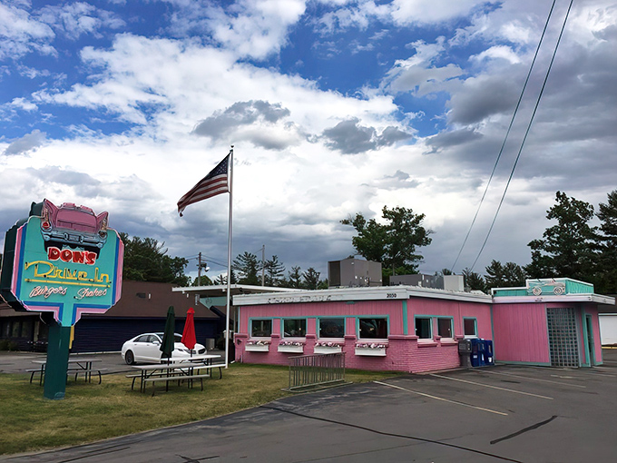 A pink paradise awaits! Don's Drive-In stands proud against the Michigan sky, its neon sign a beacon for hungry time-travelers and modern-day foodies alike.