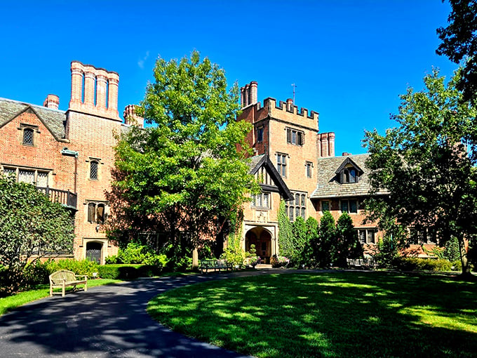 "Welcome to Downton Abbey's American cousin!" This Tudor Revival masterpiece whispers tales of Gilded Age glamour, with its imposing chimneys and manicured lawns fit for a garden party.