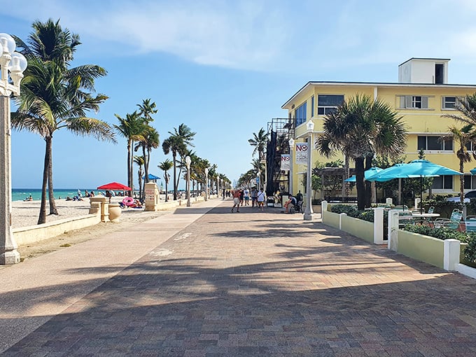 Palm trees, people, and promise: Hollywood Beach Broadwalk stretches out like a sun-soaked red carpet, inviting you to strut your stuff or leisurely stroll.