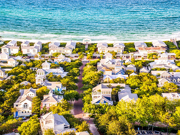 Seaside: Where pastel dreams come true! This aerial view showcases a kaleidoscope of charming cottages nestled against emerald waters. It's like a Wes Anderson film come to life.