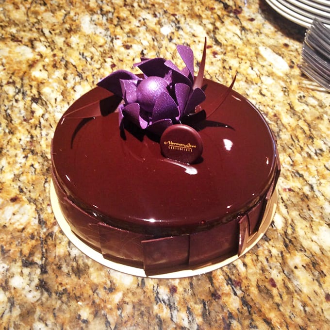 Is it a cake or a work of art? This glossy chocolate masterpiece, adorned with a purple flower, is proof that you can have your art and eat it too!