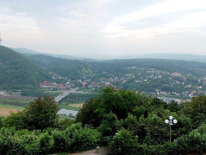 Rolling hills and lush forests stretch as far as the eye can see. It's like someone took a Bob Ross painting and made it real – happy little trees included.