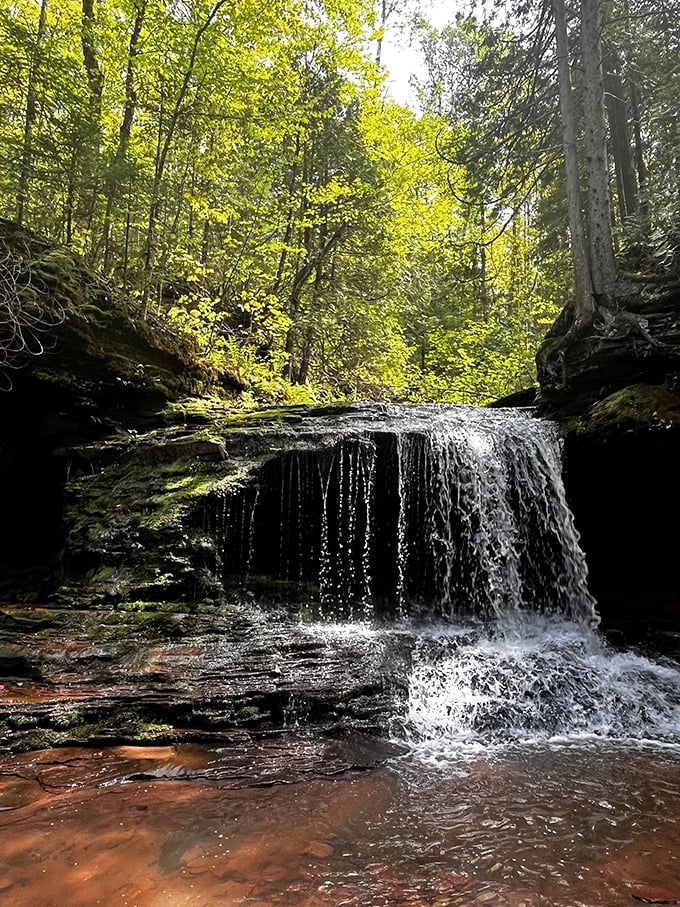 Nature's amphitheater awaits! The falls take center stage, surrounded by a verdant audience of trees and rocks.