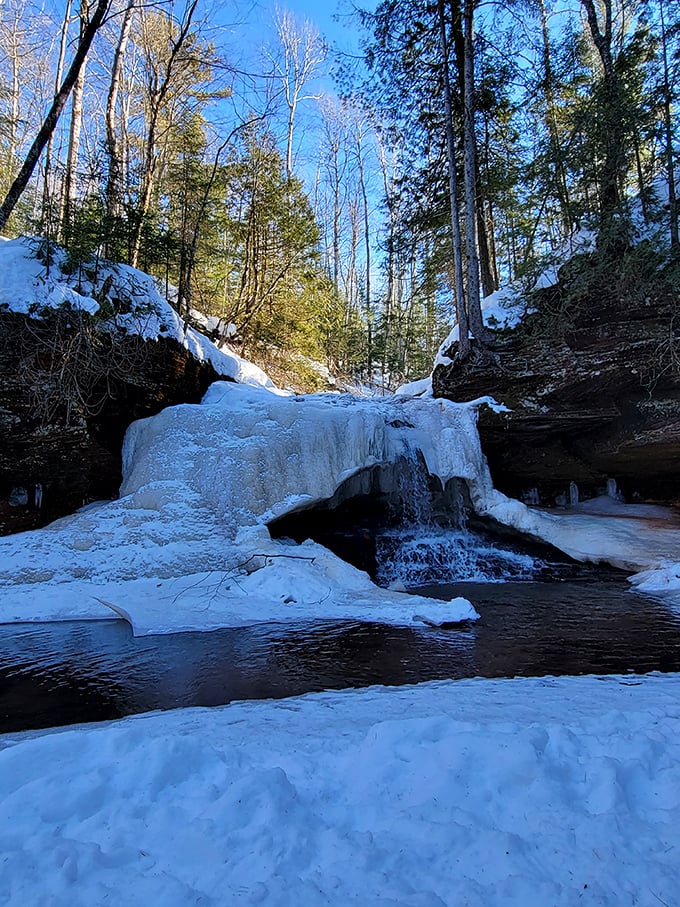 Winter's icy grip transforms the falls into a frozen wonderland. It's like nature hit the pause button on her own waterworks!