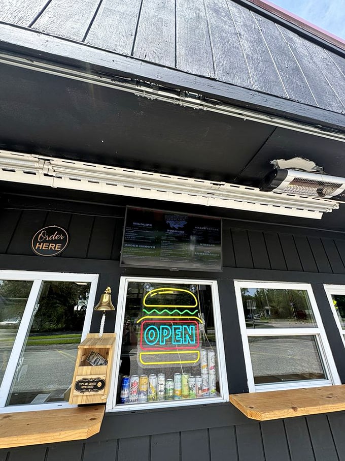 The neon burger sign glows like a beacon of hope for hungry travelers, while wooden counters add that perfect touch of rustic charm. Photo credit: Heather R.