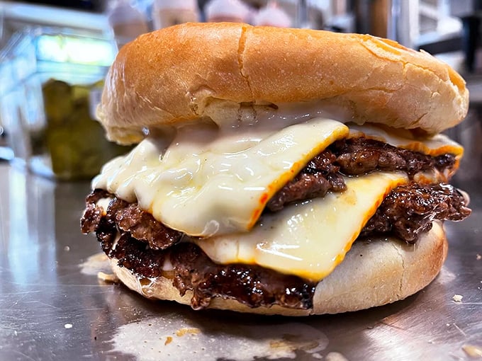 Two burgers living their best life together, draped in melted cheese and nestled in a perfectly toasted bun. Photo credit: Backwoods Burger Shack