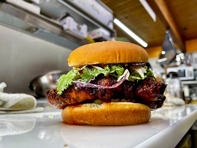 Perfectly seasoned and fried until golden, this chicken sandwich, topped with fresh greens, is what comfort food dreams are made of. Photo credit: Backwoods Burger Shack