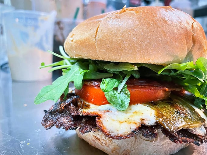 Fresh greens and ripe tomatoes add a garden-fresh crunch to this perfectly charred burger – nature and nurture in perfect harmony. Photo credit: Backwoods Burger Shack