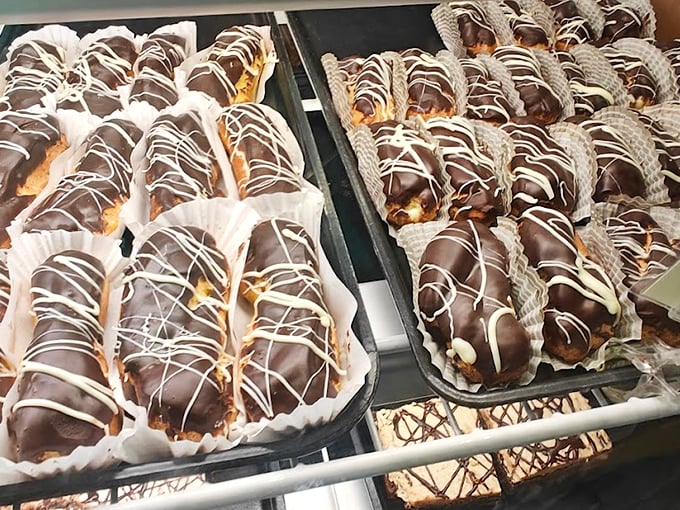 Chocolate-dipped eclairs lined up like edible works of art, each one promising a moment of pure pastry bliss. Photo credit: Mark Heydenburg