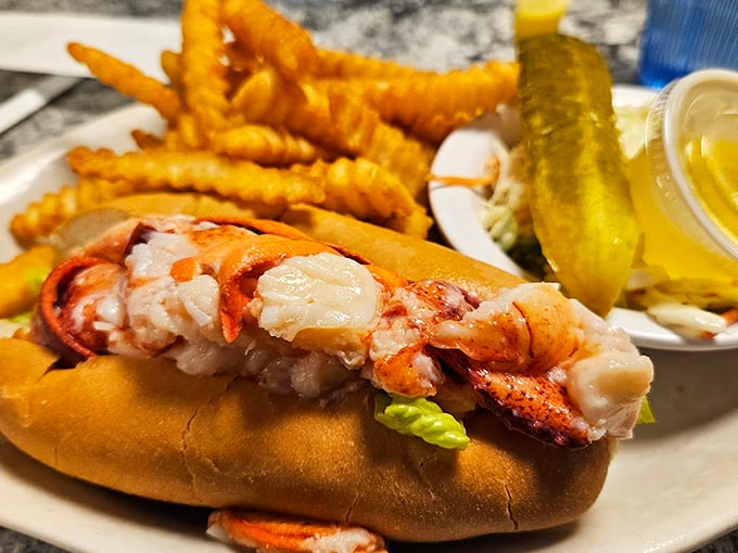 This isn't just a lobster roll - it's a celebration of Maine's finest, served with golden fries and a pickle standing guard. Photo credit: Holly A