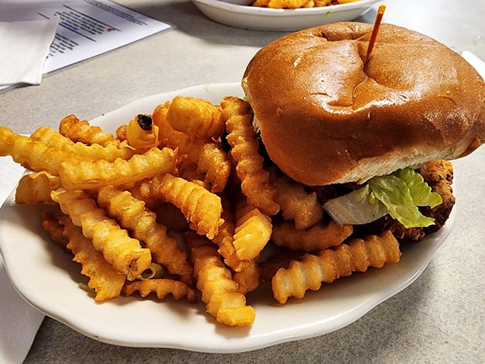 Comfort food done right: a towering burger and crispy waffle fries that would make any diner proud. Photo credit: Betsy Cwikla