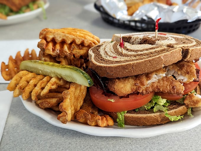 A sandwich that means business, stacked high with fresh ingredients and paired with those addictive waffle fries. Photo credit: John Turnmire