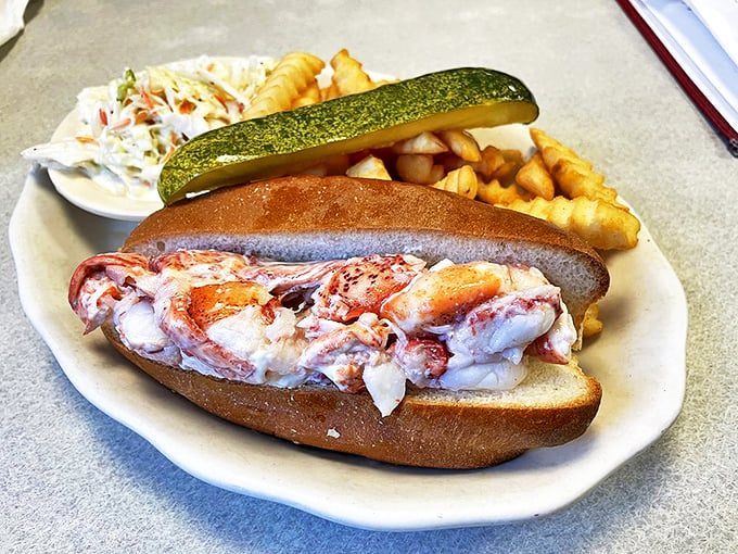 The lobster roll of your dreams: perfectly toasted bun, generous chunks of fresh lobster, and that pickle standing guard like a sentry. Photo credit: Paul A