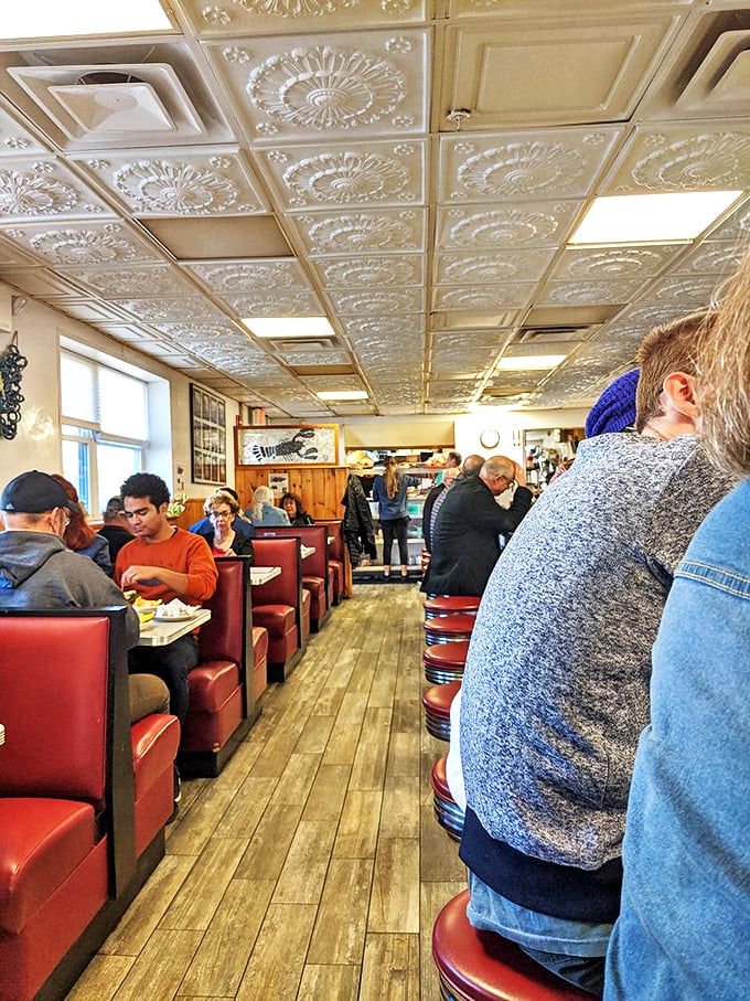 Red vinyl booths stretch into infinity, each one holding countless memories of meals shared and stories told. Photo credit: Coreen W.