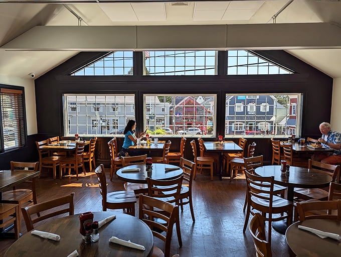 Sunlight streams through expansive windows, creating the perfect backdrop for memorable meals in this warm, welcoming dining room. Photo credit: William Cheng