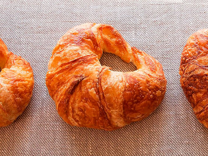 Golden, flaky, and utterly irresistible. These croissants are so perfectly curved, they could teach geometry. Time for a buttery breakfast adventure! Photo credit: Beach Pea Baking Co