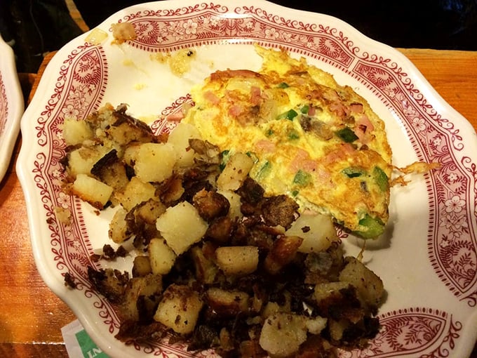 Home fries that'll make you want to move in! Crispy, seasoned potato nuggets nestled next to an omelet that's clearly living its best life.